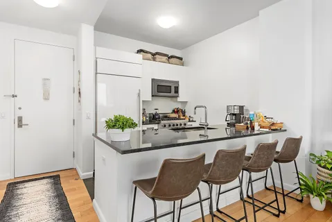 a kitchen with stainless steel appliances granite countertop a sink and a refrigerator