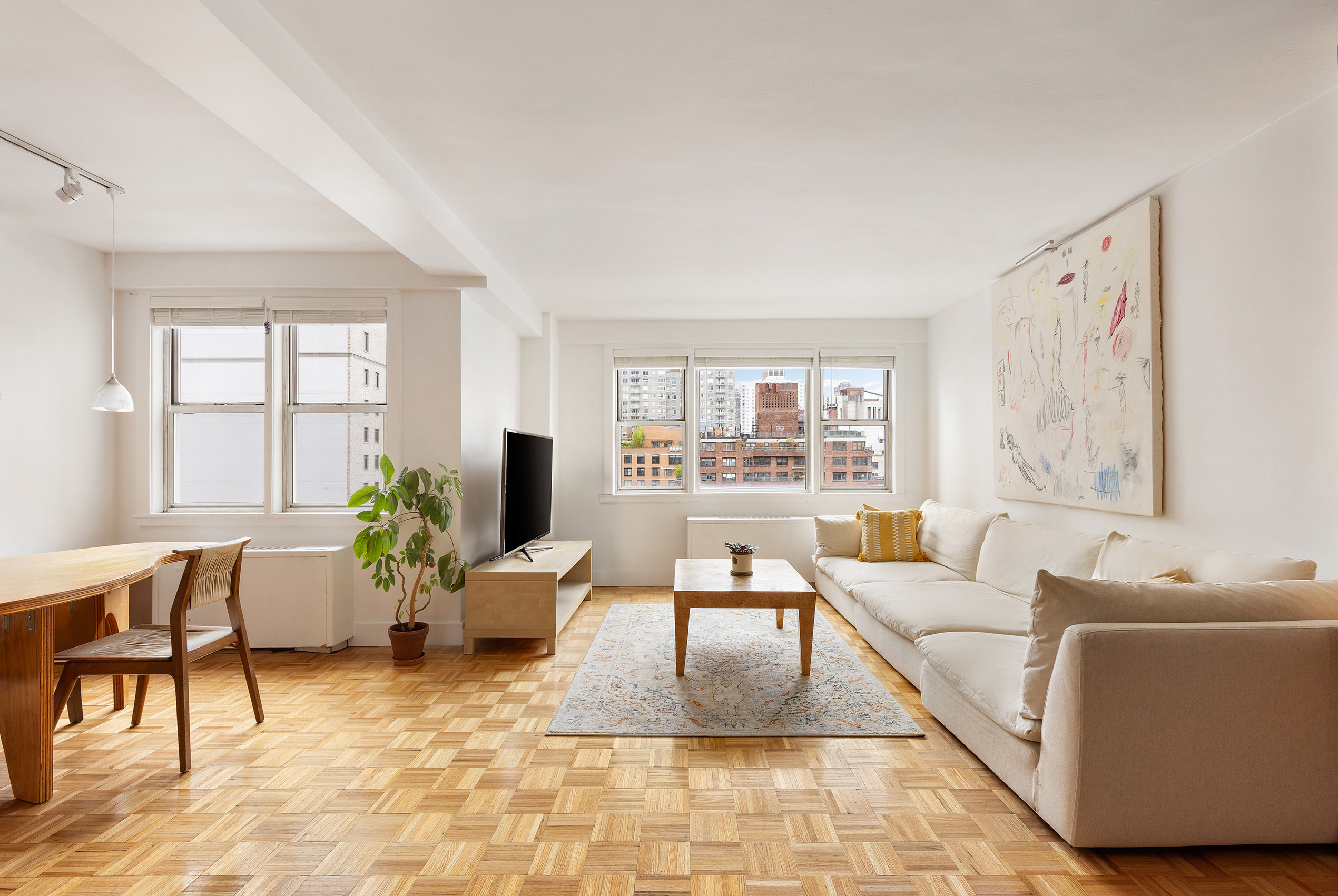 525 East 82nd Street, Unit 12E Manhattan, NY 10028 - Photo 2 of 29 a living room with furniture and a large window