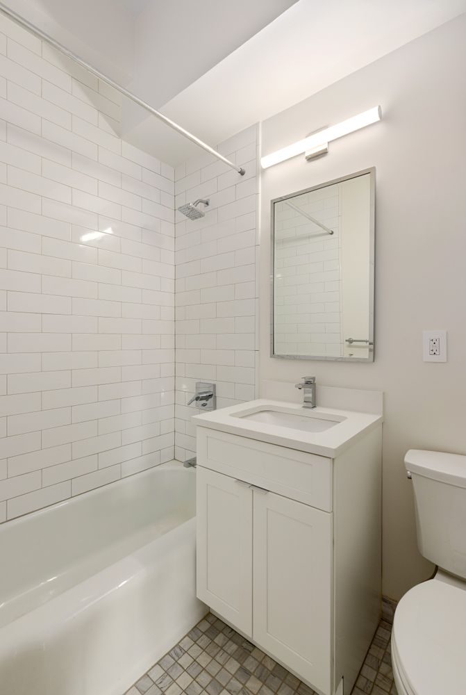 11 Riverside Drive, Unit 17E Manhattan, NY 10023 - Photo 9 of 16 a bathroom with a sink a toilet and shower