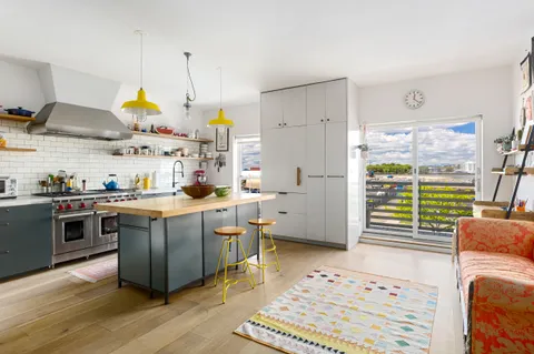 a kitchen with kitchen island granite countertop a sink a counter top space and stainless steel appliances
