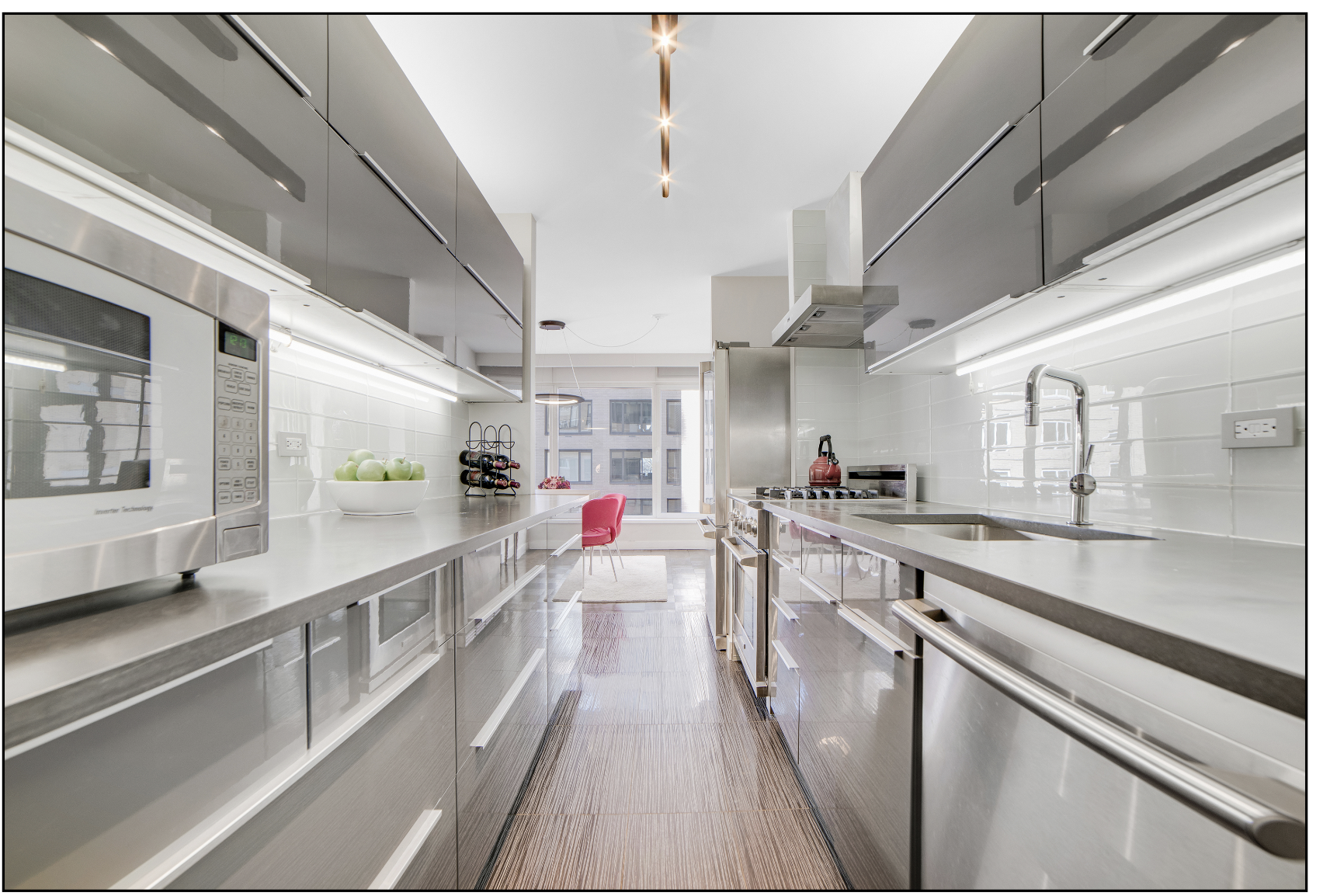 200 Central Park South, Unit 7Q Manhattan, NY 10019 - Photo 3 of 6 a kitchen with stainless steel appliances sink stove and cabinets
