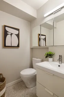 a bathroom with a toilet a sink and mirror