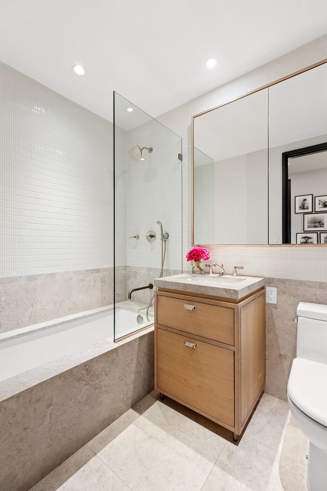 a bathroom with a tub sink and mirror