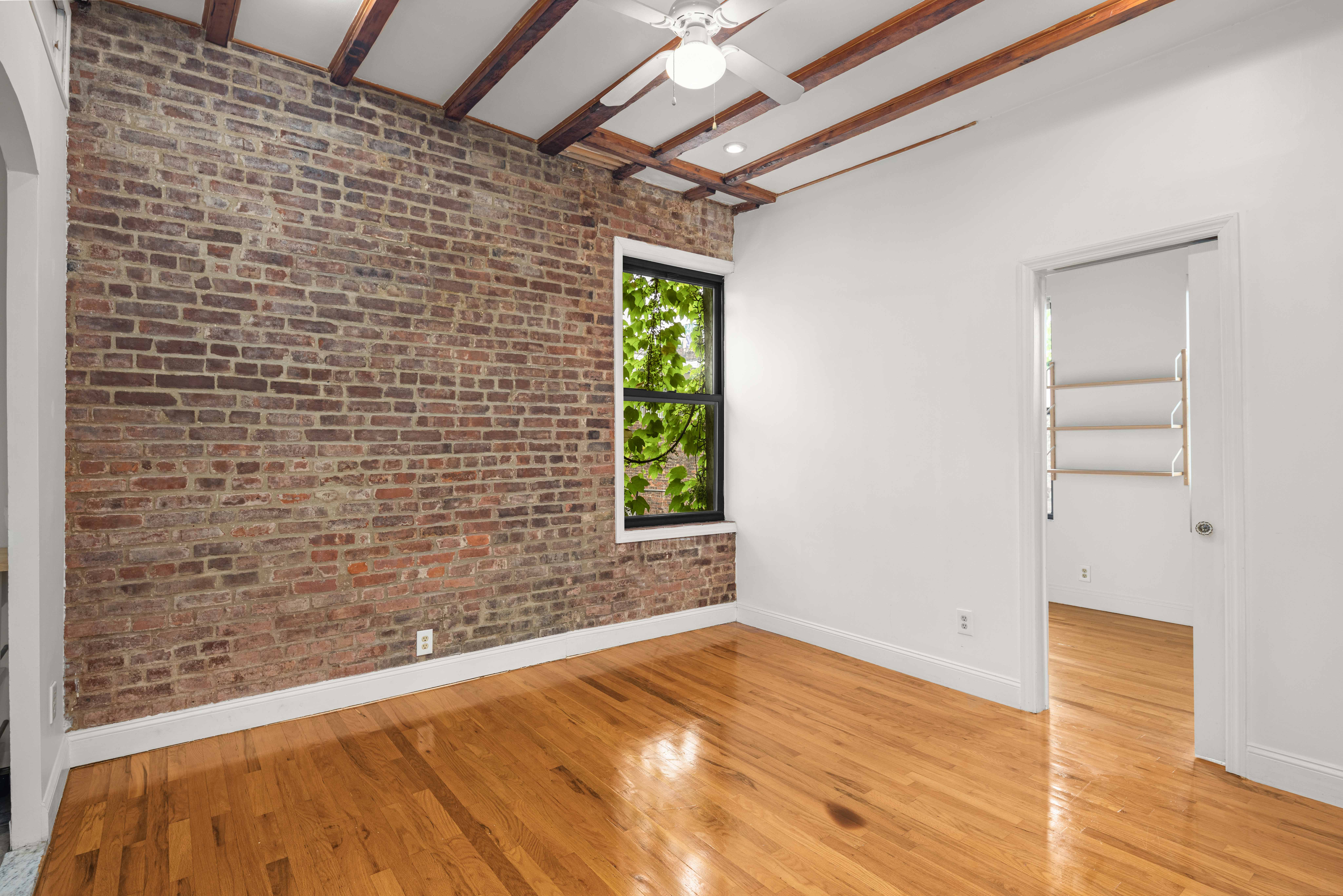 120 Suffolk Street, Unit 5B Manhattan, NY 10002 - Photo 4 of 14 a view of empty room with wooden floor and fan
