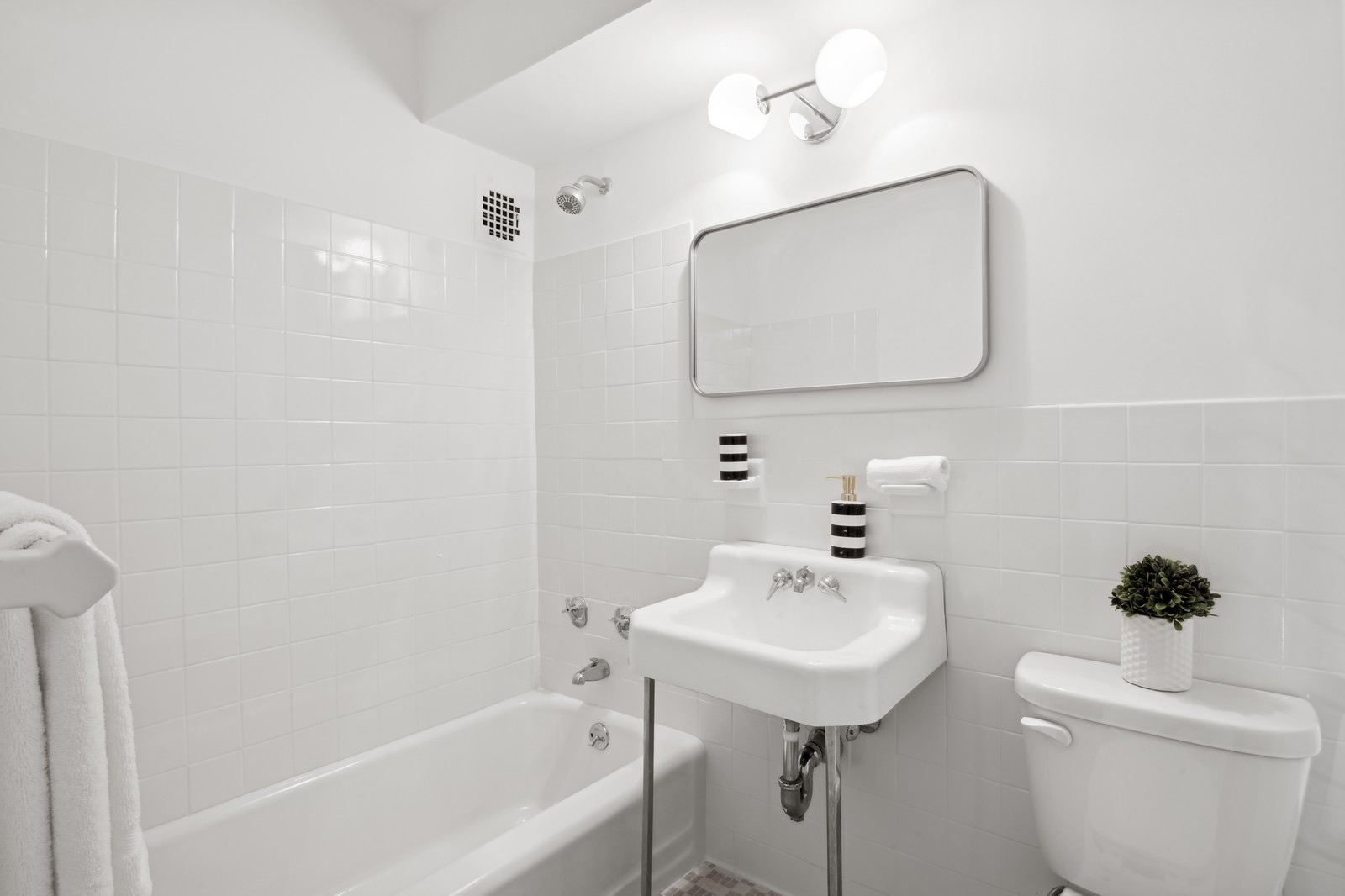 303 West 66th Street, Unit 6BW Manhattan, NY 10023 - Photo 7 of 12 a bathroom with a sink a toilet and shower