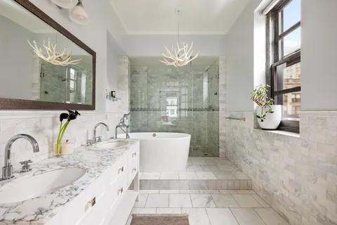 a bathroom with a granite countertop sink a toilet a mirror and shower