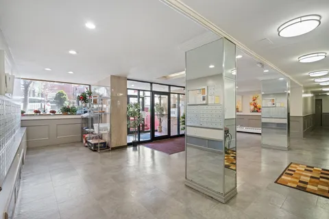 a view of a hall with kitchen and living room