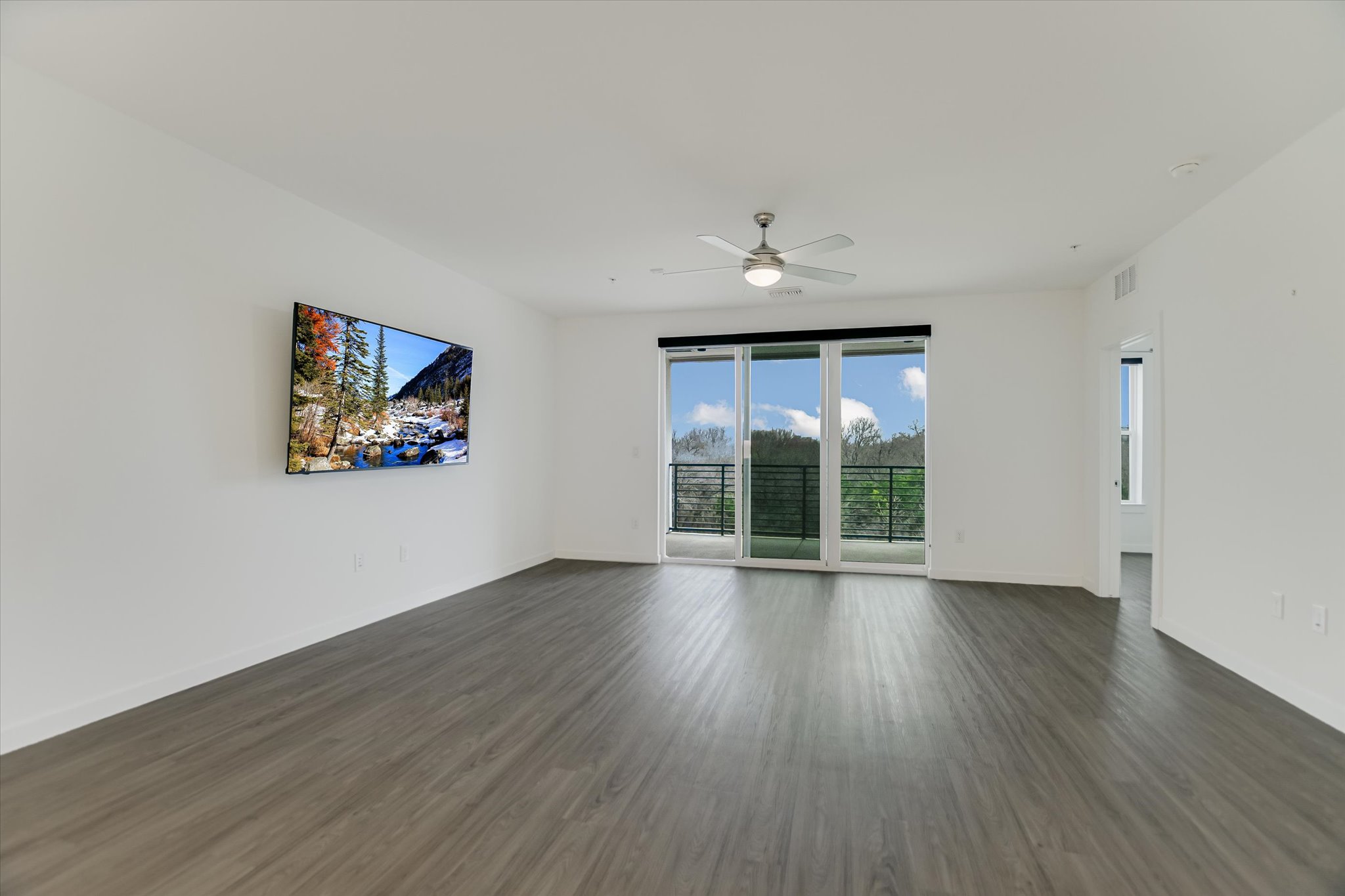 4801 Springdale Road, Unit 1207 Austin, TX 78723 - Photo 4 of 10 an empty room with wooden floor and windows