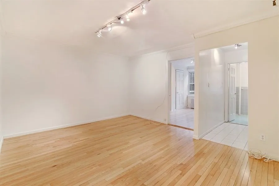 a view of empty room with wooden floor