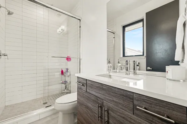 a bathroom with a sink a toilet and shower