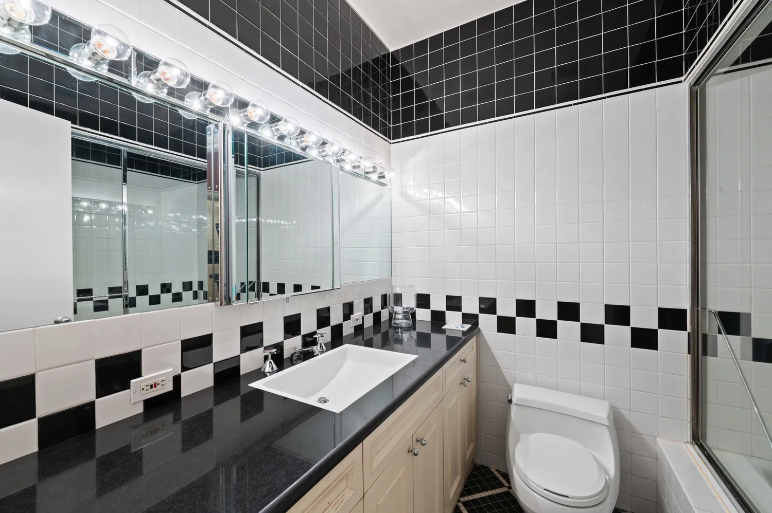 a bathroom with a sink a toilet a mirror and shower