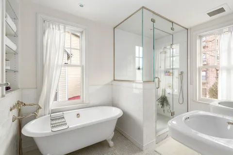 a bathroom with a tub a sink and a window