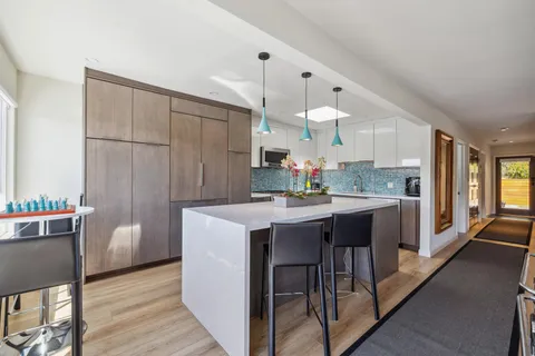 a kitchen with stainless steel appliances a sink a stove top oven a counter space and cabinets