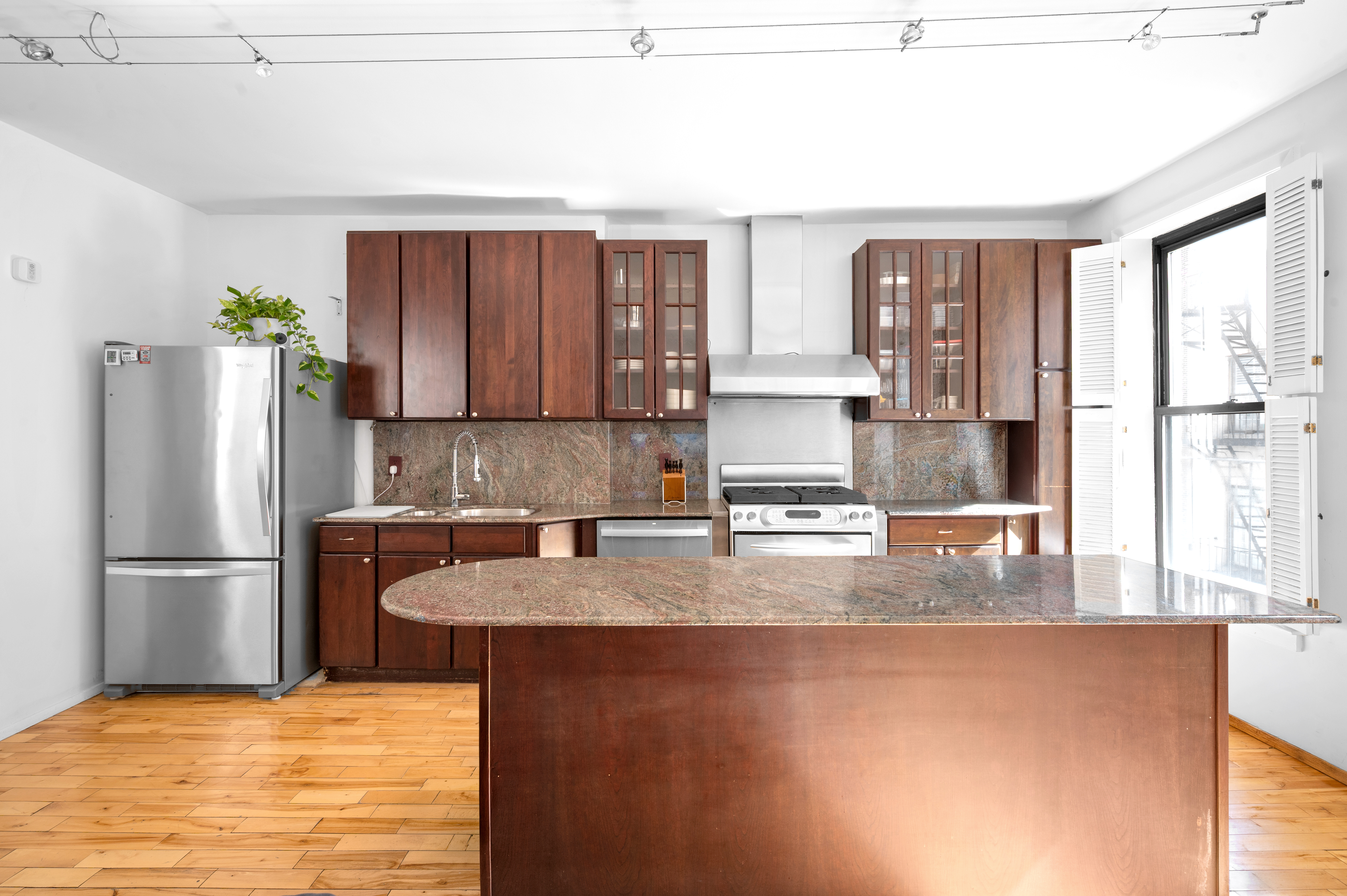 206 West 85th Street, Unit 5 Manhattan, NY 10024 - Photo 3 of 15 a kitchen with stainless steel appliances granite countertop a refrigerator a stove and a sink with wooden cabinets