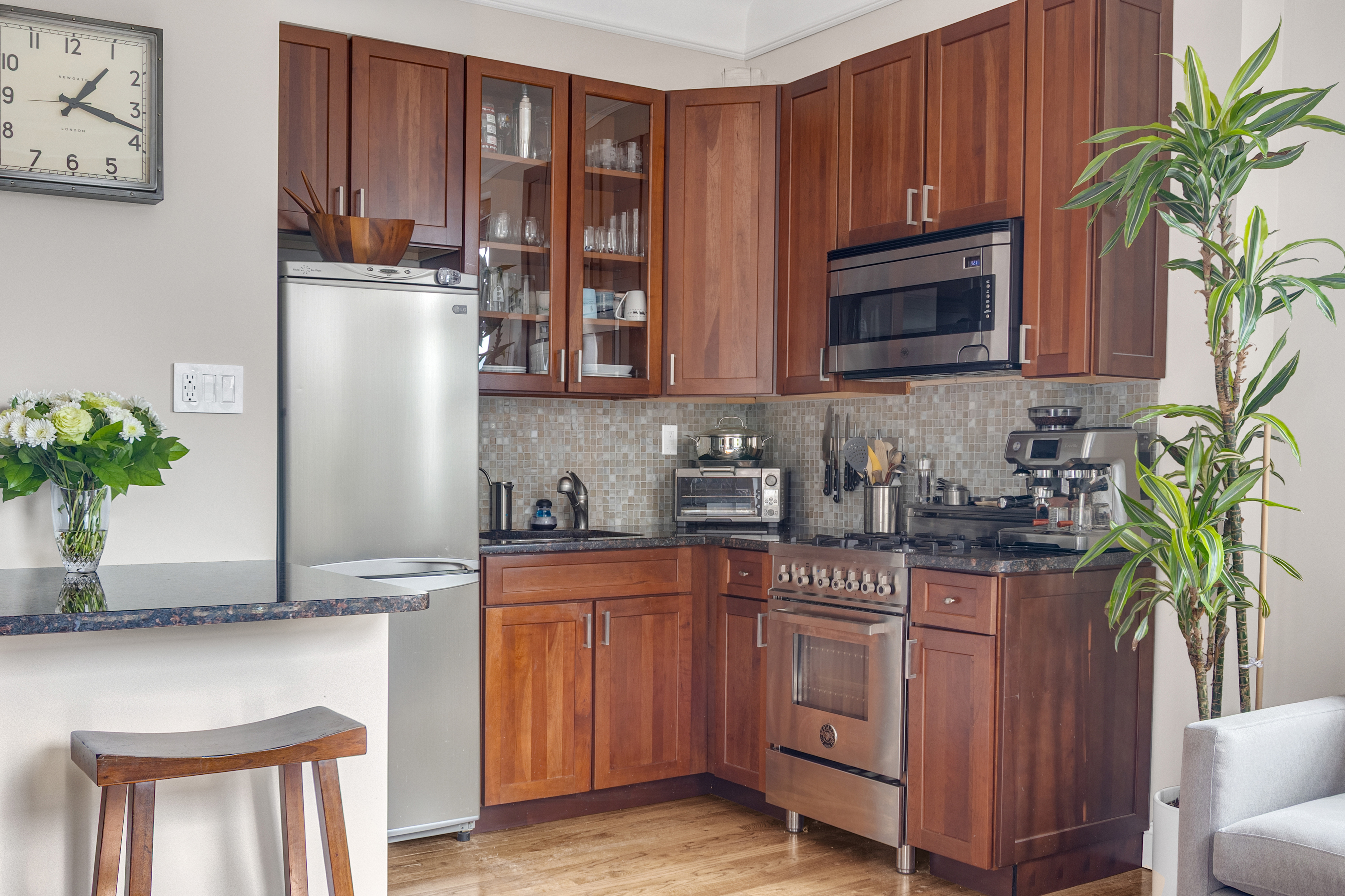 51 West 81st Street, Unit 9D Manhattan, NY 10024 - Photo 3 of 15 a kitchen with stainless steel appliances granite countertop a refrigerator a stove a sink and a potted plant