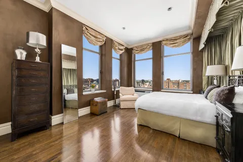 a spacious bedroom with a large bed and a large window