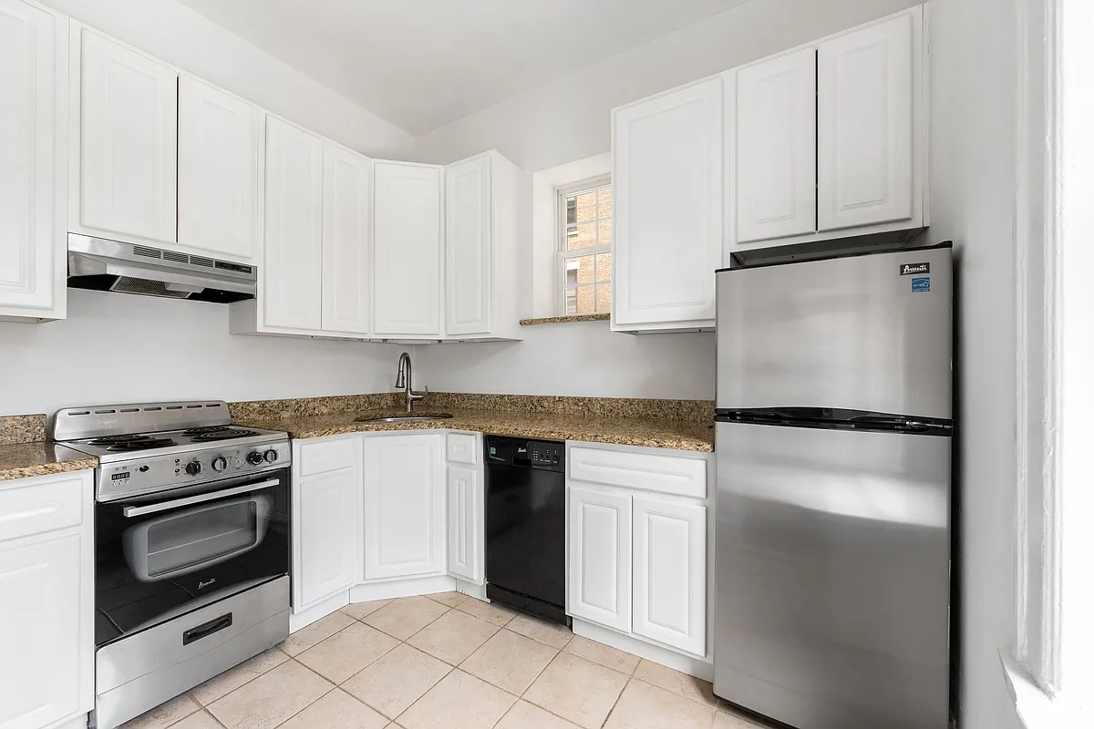 167 West 72nd Street Manhattan, NY 10023 - Photo 7 of 25 a kitchen with a refrigerator stove and white cabinets