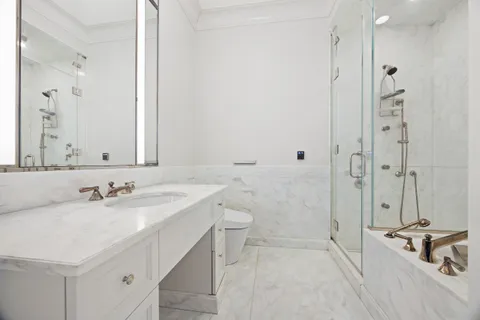 a bathroom with a sink a toilet and shower