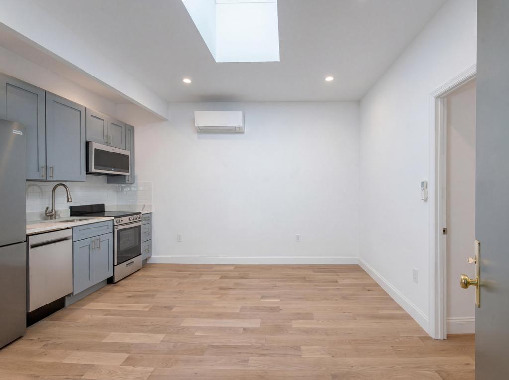 a kitchen with granite countertop a stove top oven a sink dishwasher and a refrigerator with wooden floor