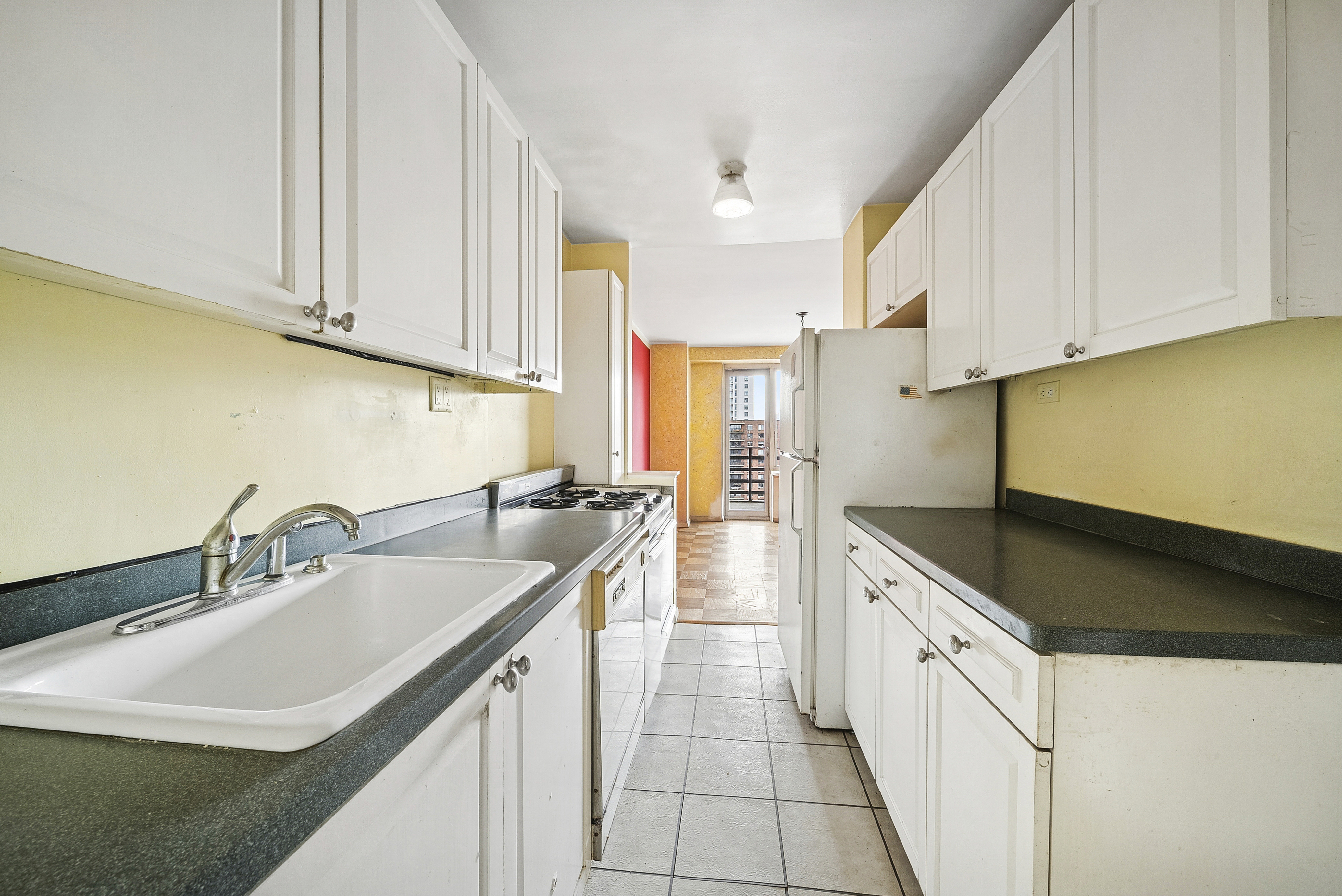 400 Central Park West, Unit 20B Manhattan, NY 10025 - Photo 6 of 11 a kitchen with stainless steel appliances granite countertop a sink and cabinets