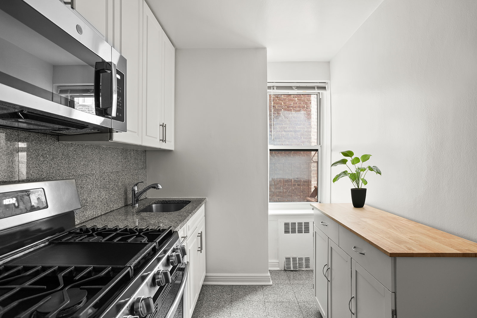 33-16 82nd Street, Unit 4C Queens, NY 11372 - Photo 3 of 13 a kitchen with a stove and white cabinets