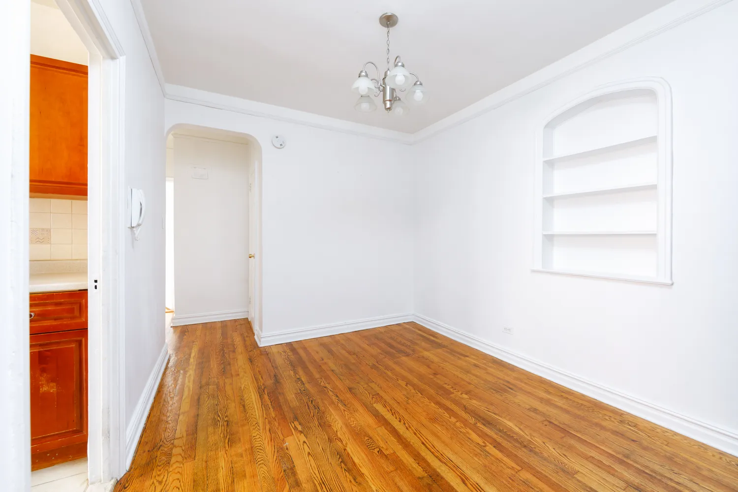 a view of a room with wooden floor and a bathroom