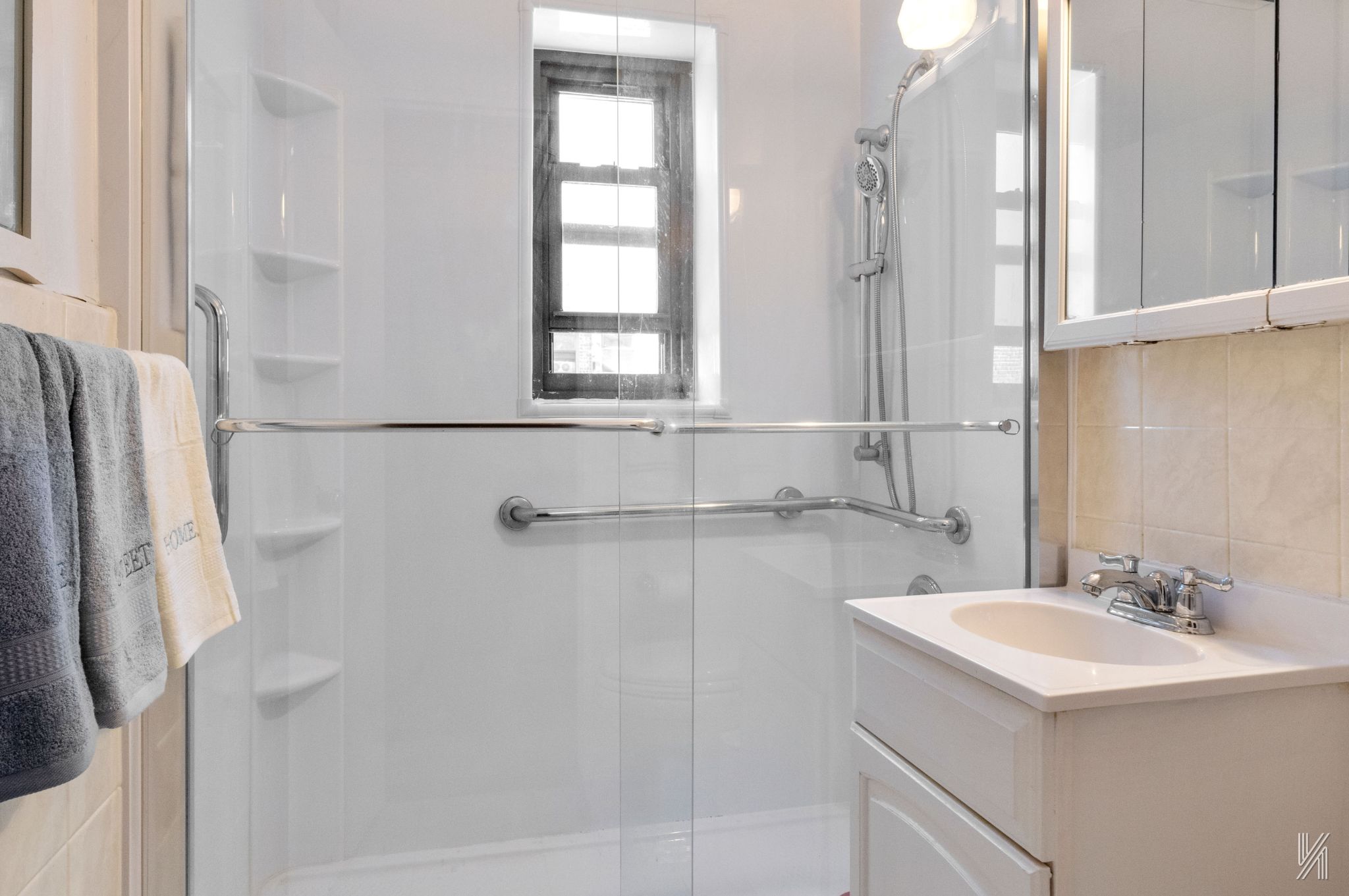 34-10 94th Street, Unit 3D Queens, NY 11372 - Photo 15 of 17 a bathroom with a sink a mirror and a shower