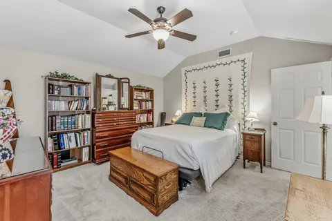 a bedroom with a bed furniture and a book shelf