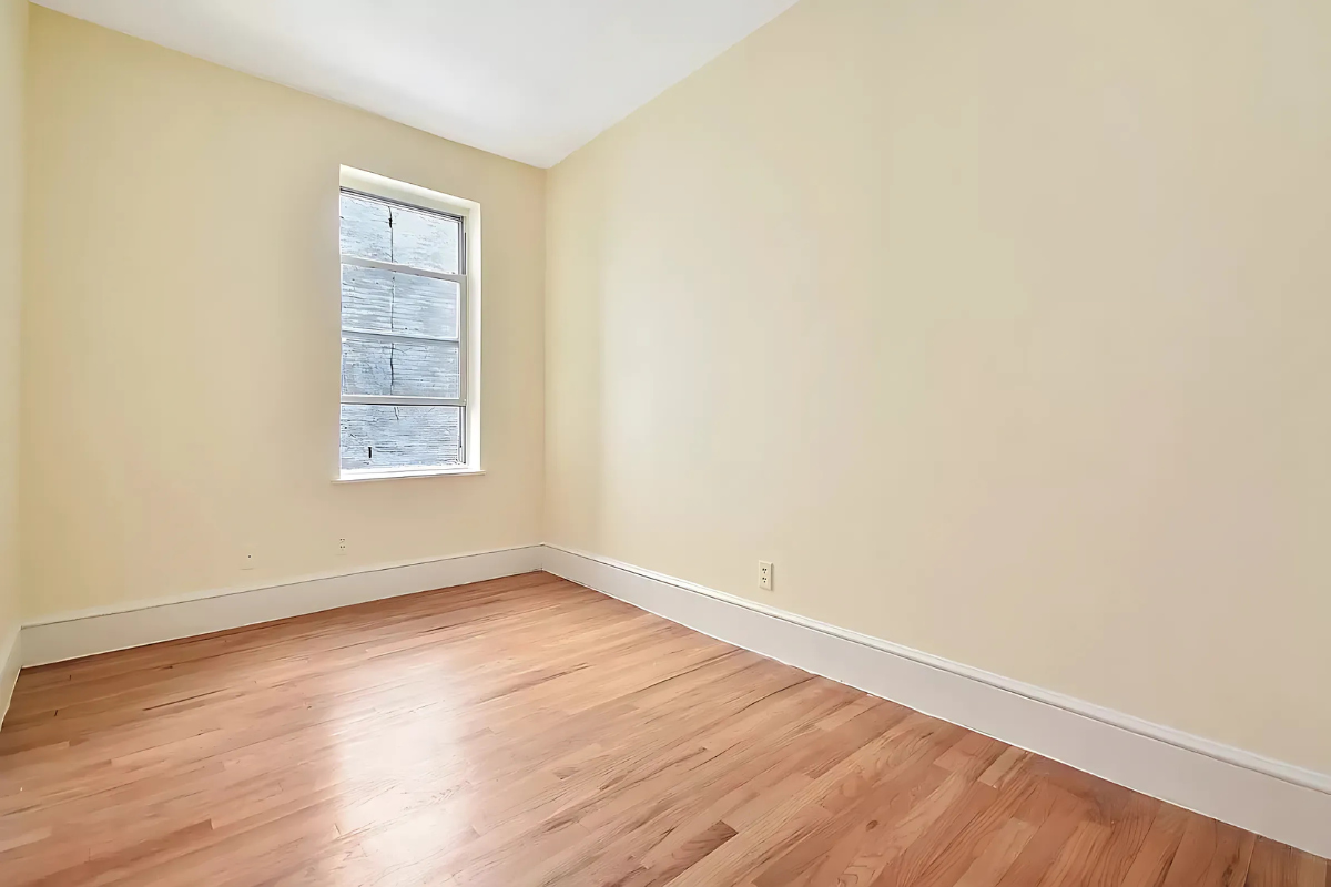 247 East 81st Street, Unit 3E Manhattan, NY 10028 - Photo 3 of 6 an empty room with wooden floor and windows