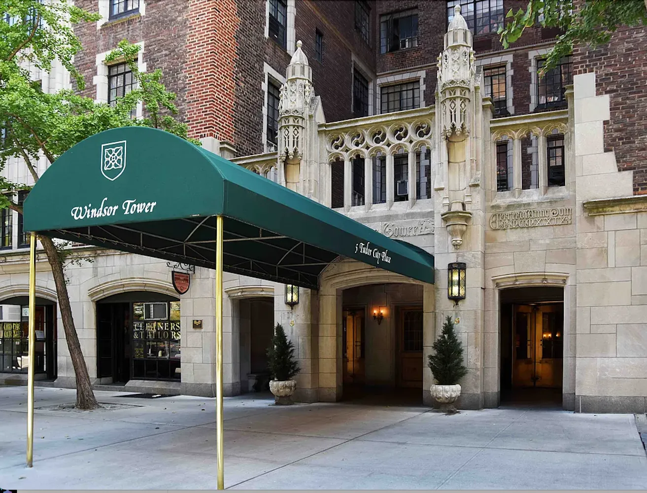 a front view of a building with glass windows and a tree