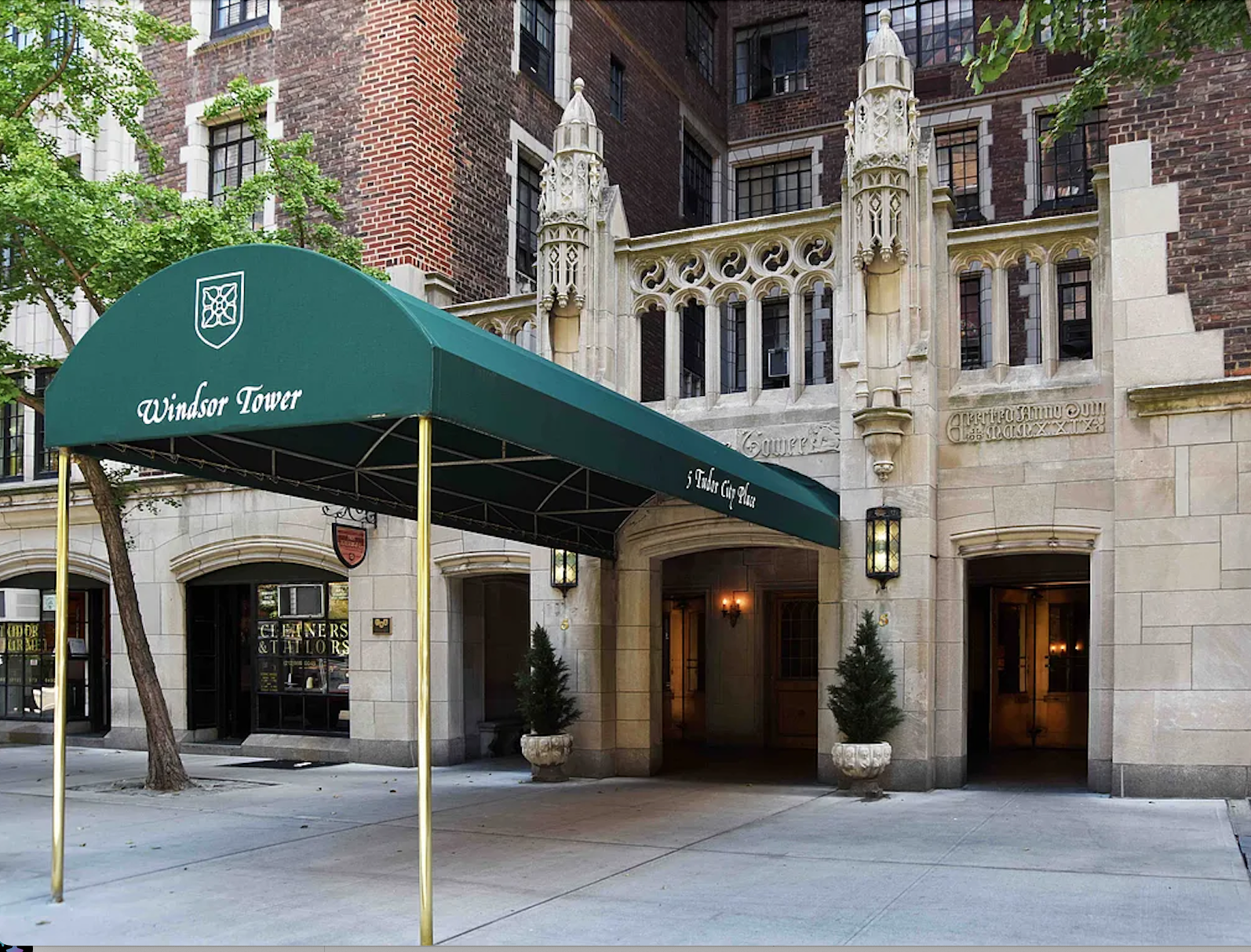 5 Tudor City Place, Unit 602 Manhattan, NY 10017 - Photo 16 of 20 a front view of a building with glass windows and a tree
