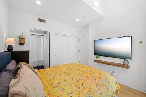 a bedroom with a bed and a flat screen tv