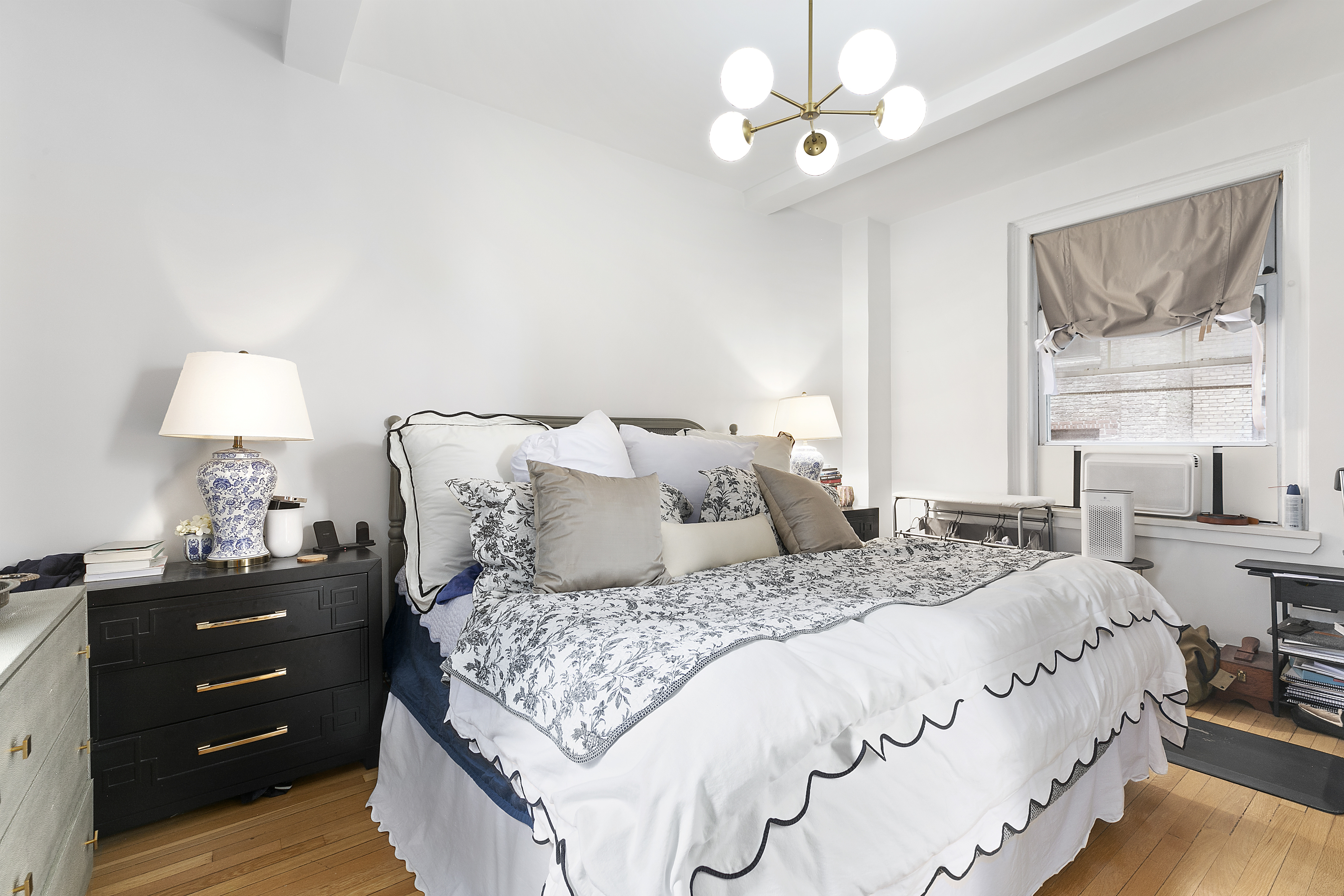 162 West 56th Street, Unit 602 Manhattan, NY 10019 - Photo 4 of 7 a bedroom with a large bed and a window