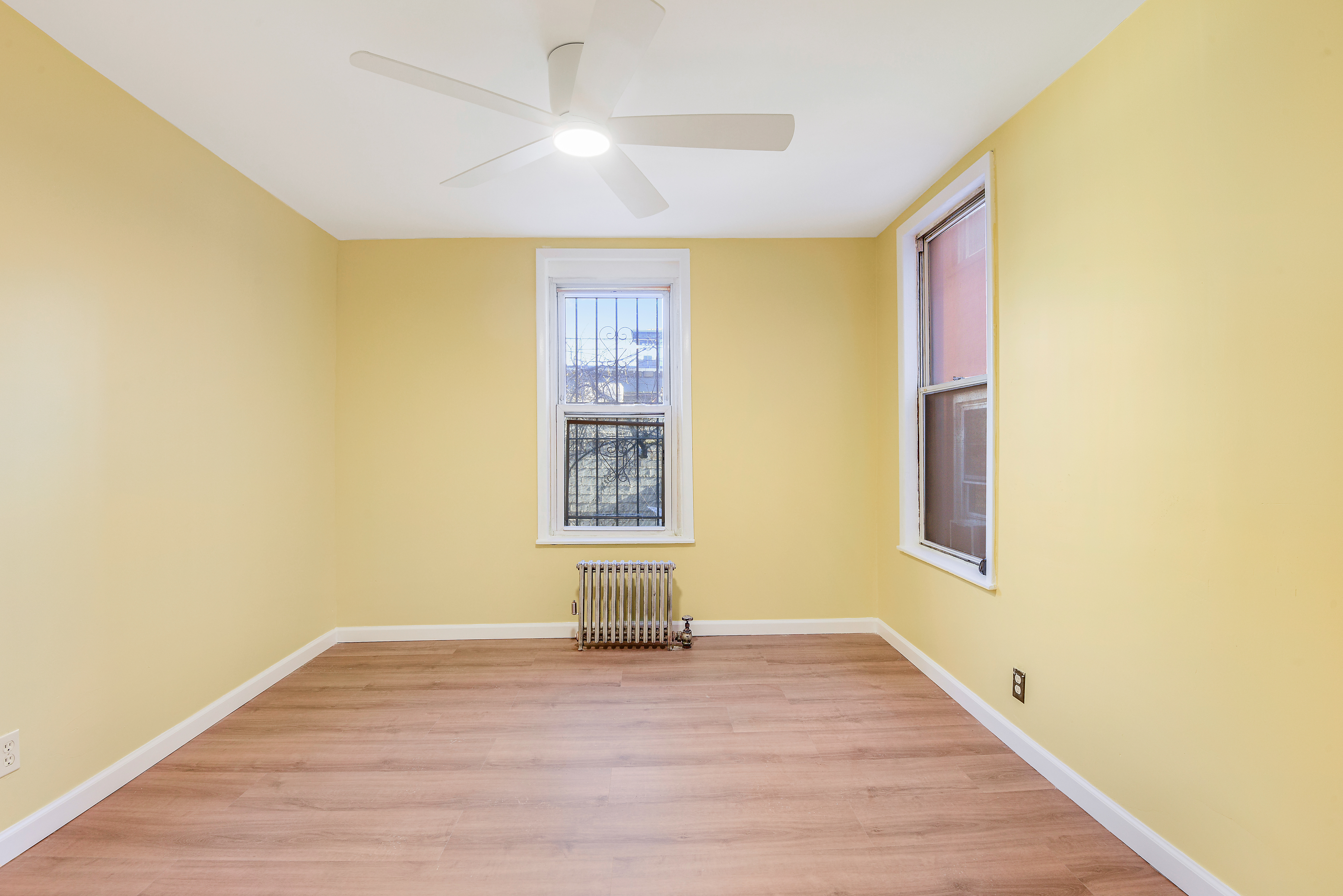 35-47 30th Street, Unit 1 Queens, NY 11106 - Photo 11 of 15 a view of empty room with wooden floor and fan