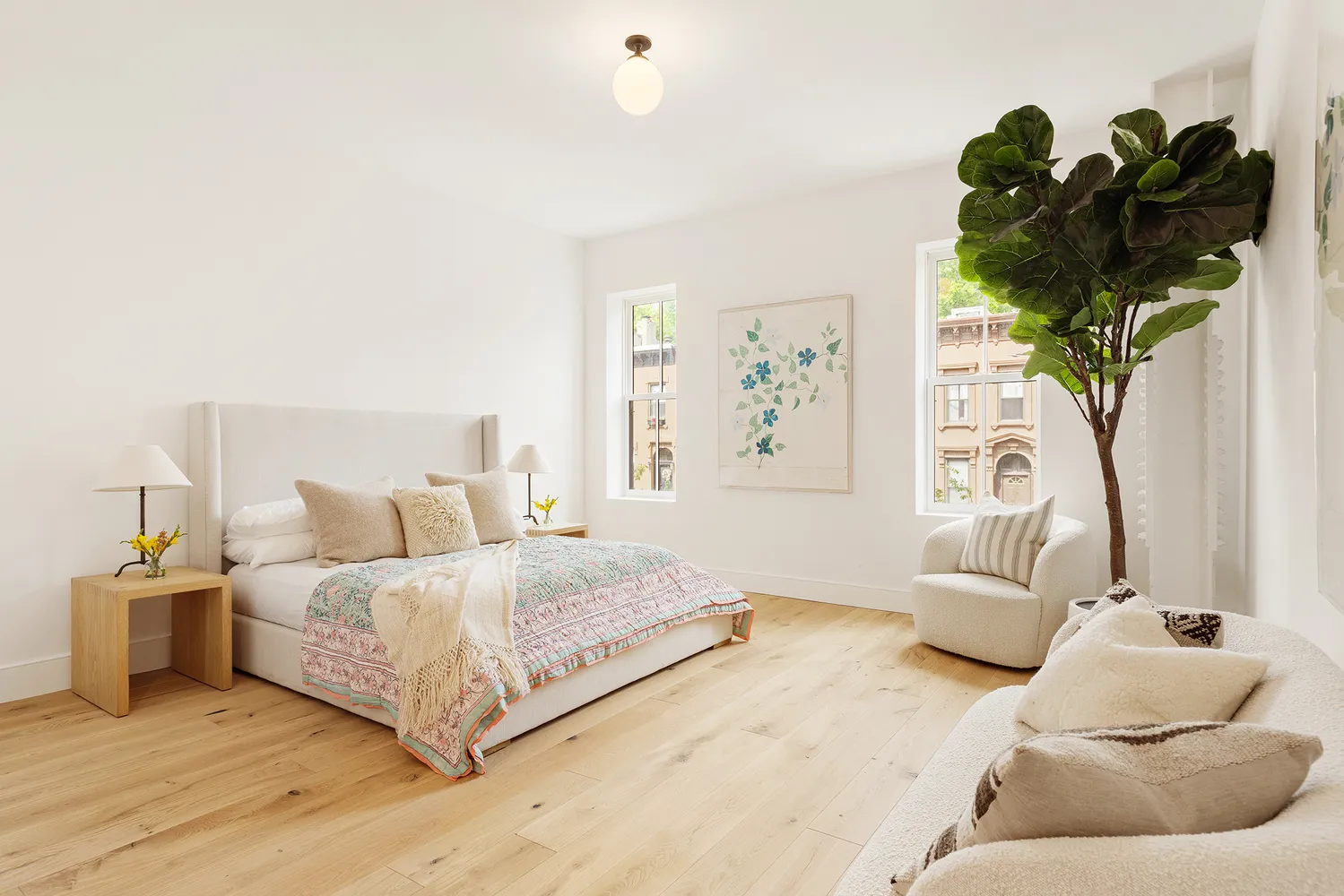 a bedroom with a bed potted plant with the wooden floor