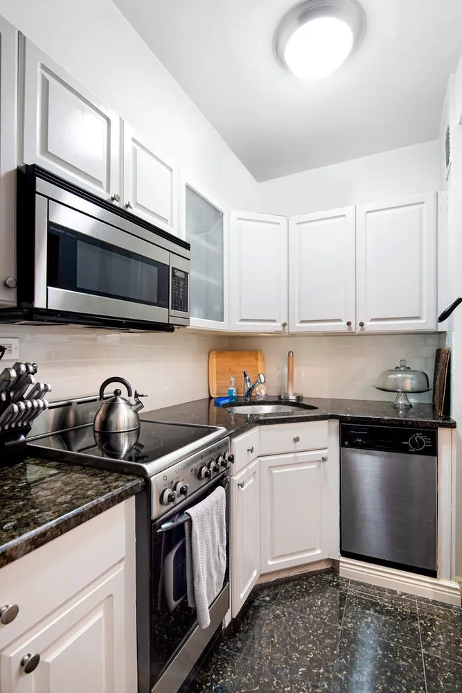 a kitchen with stainless steel appliances granite countertop a stove a sink and a microwave