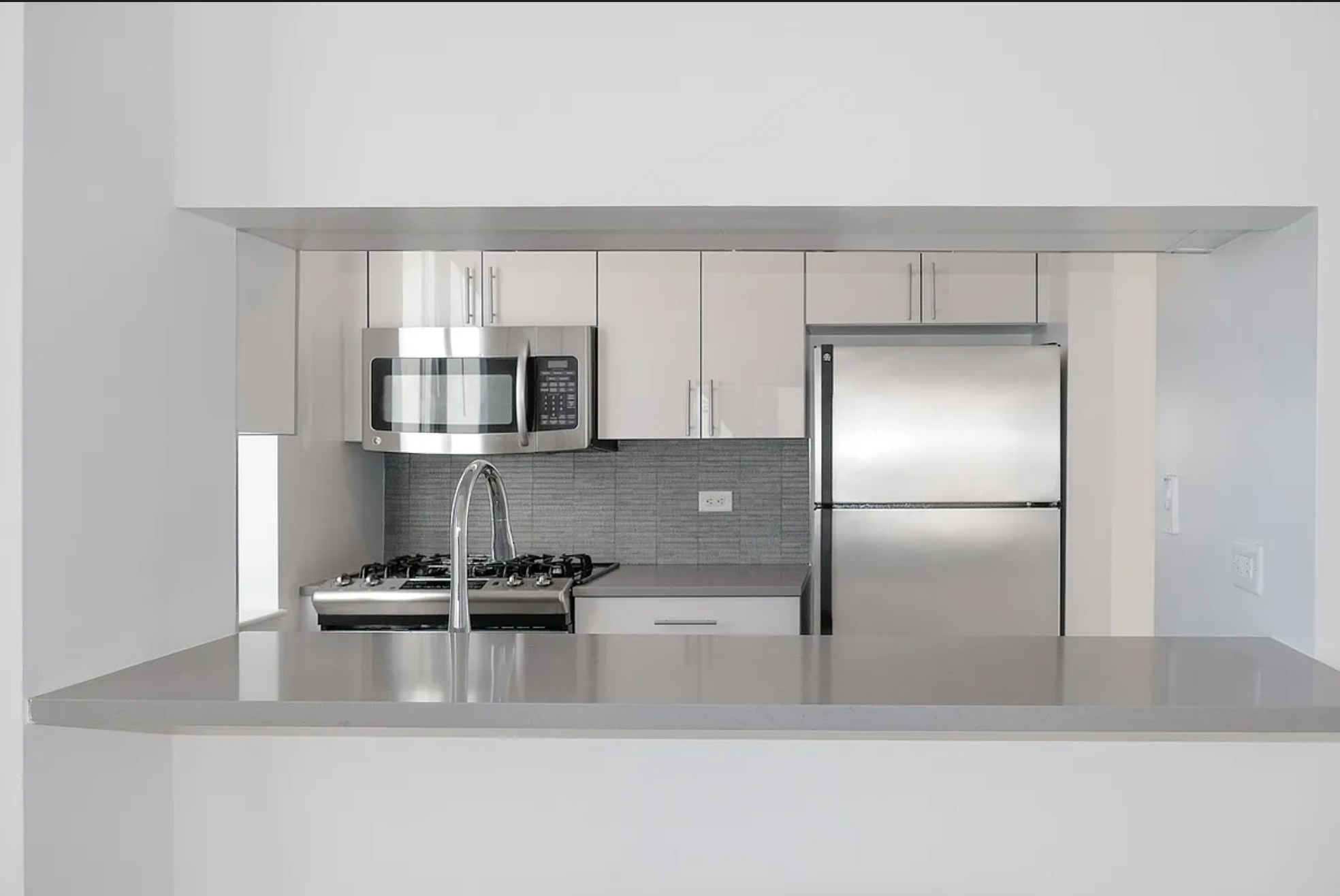 150 East 44th Street, Unit 36C Manhattan, NY 10017 - Photo 2 of 16 a kitchen with stainless steel appliances granite countertop a refrigerator and a stove