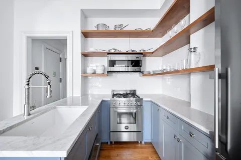 a kitchen with stainless steel appliances granite countertop a sink and wooden cabinets