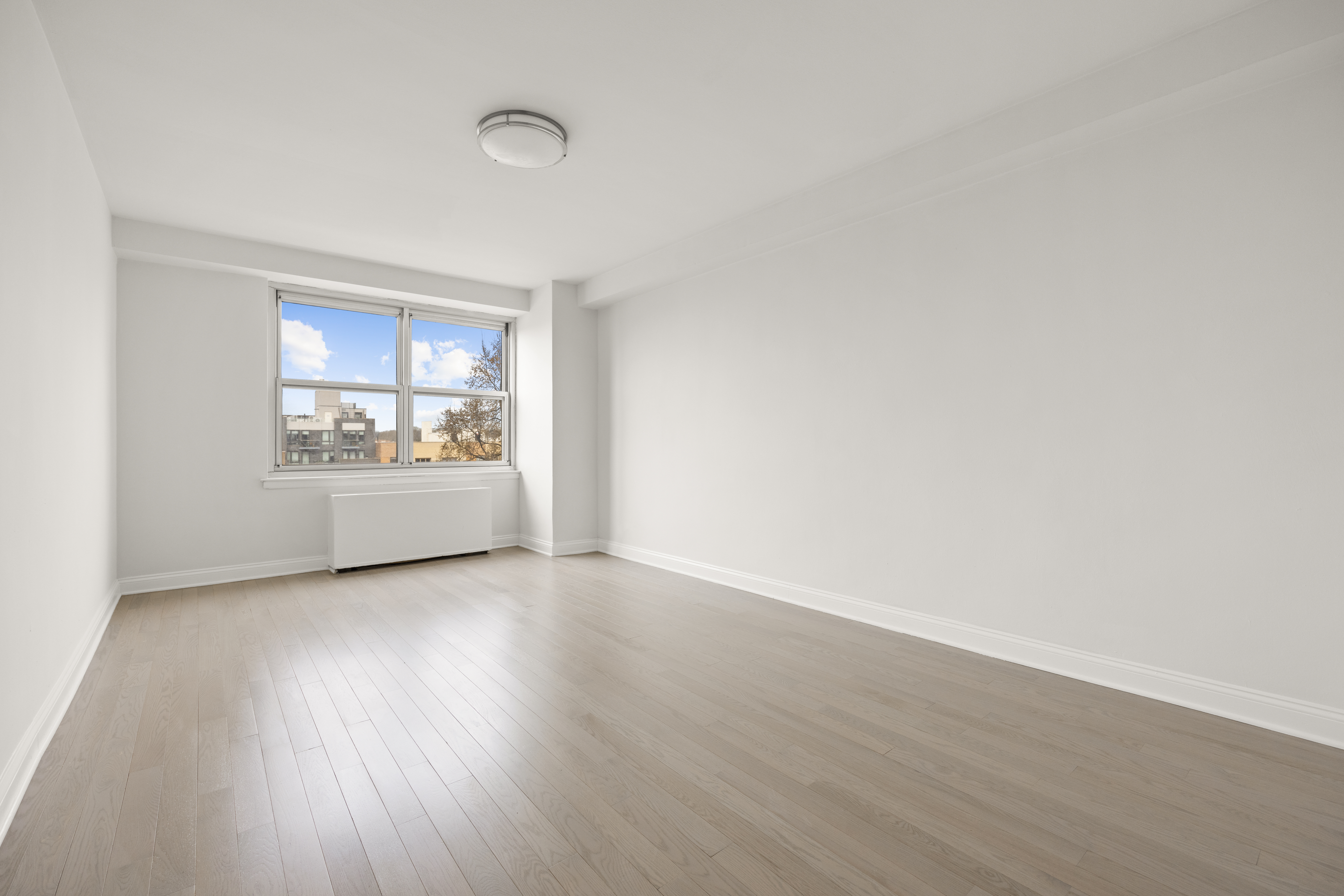 135 Ocean Parkway, Unit 9M Brooklyn, NY 11218 - Photo 17 of 18 an empty room with wooden floor and windows