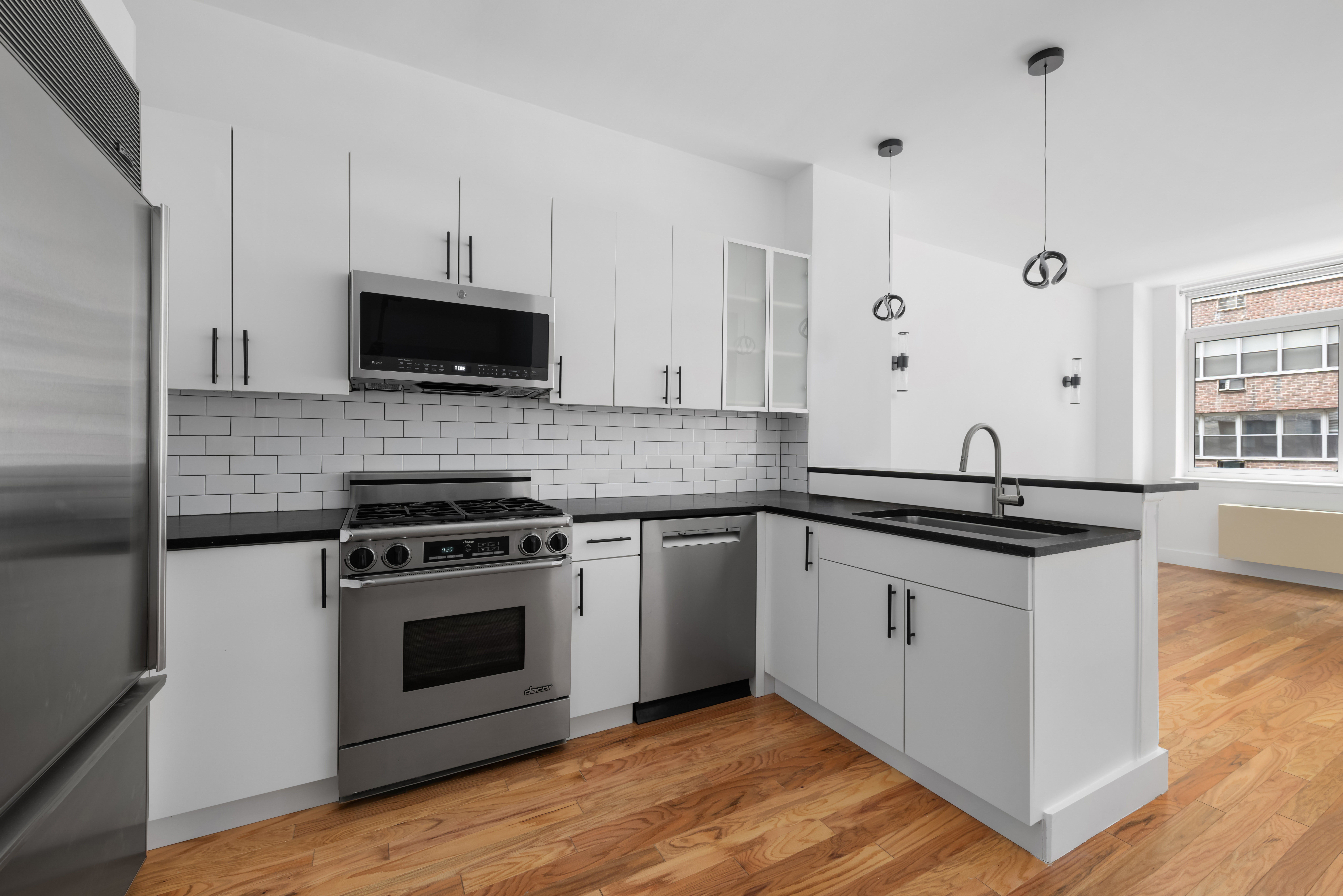 212 East 57th Street, Unit 3B Manhattan, NY 10022 - Photo 1 of 17 a kitchen with stainless steel appliances a stove a sink and a microwave