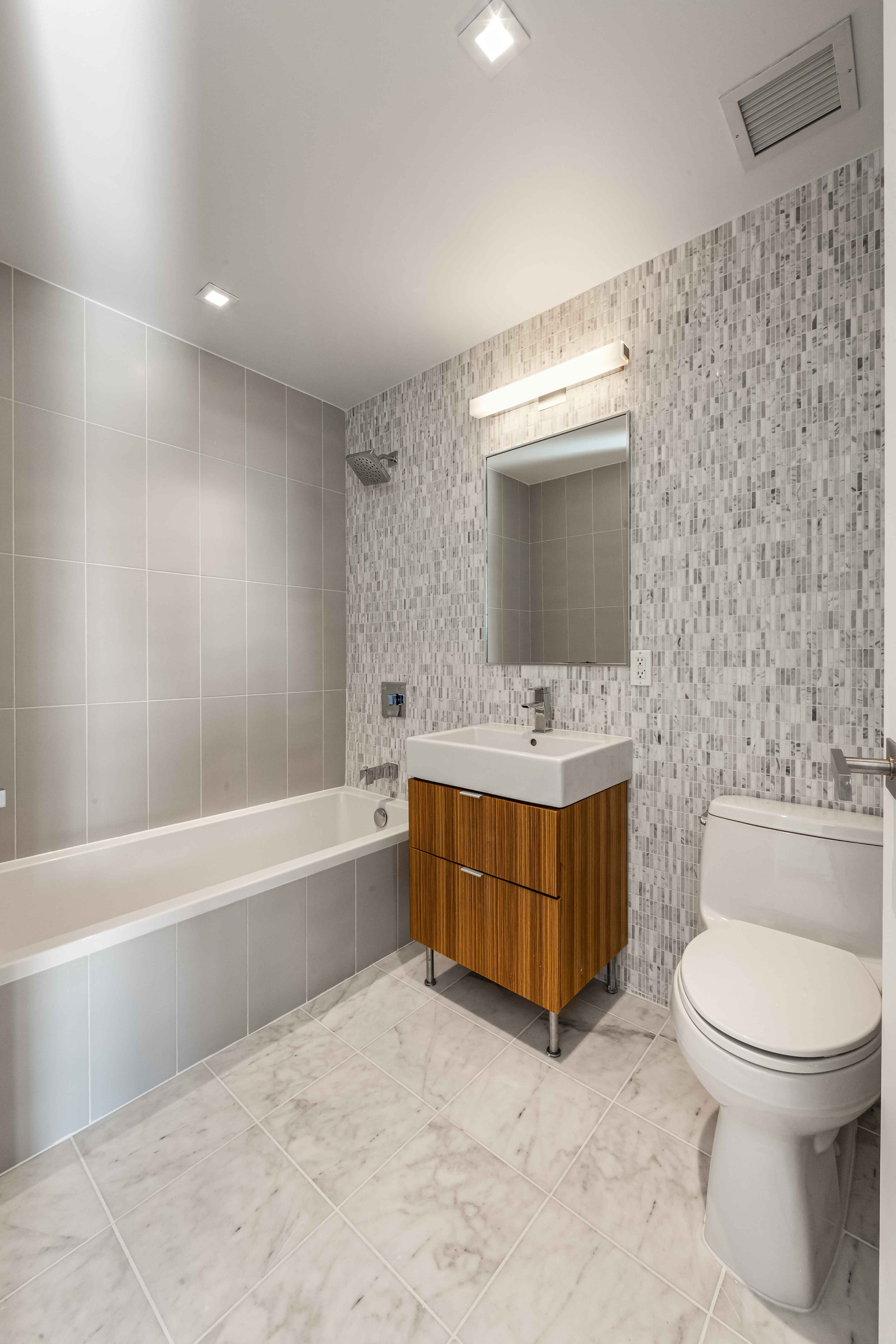 202 8th Street, Unit 8A Brooklyn, NY 11215 - Photo 14 of 21 a bathroom with a tub sink toilet and mirror