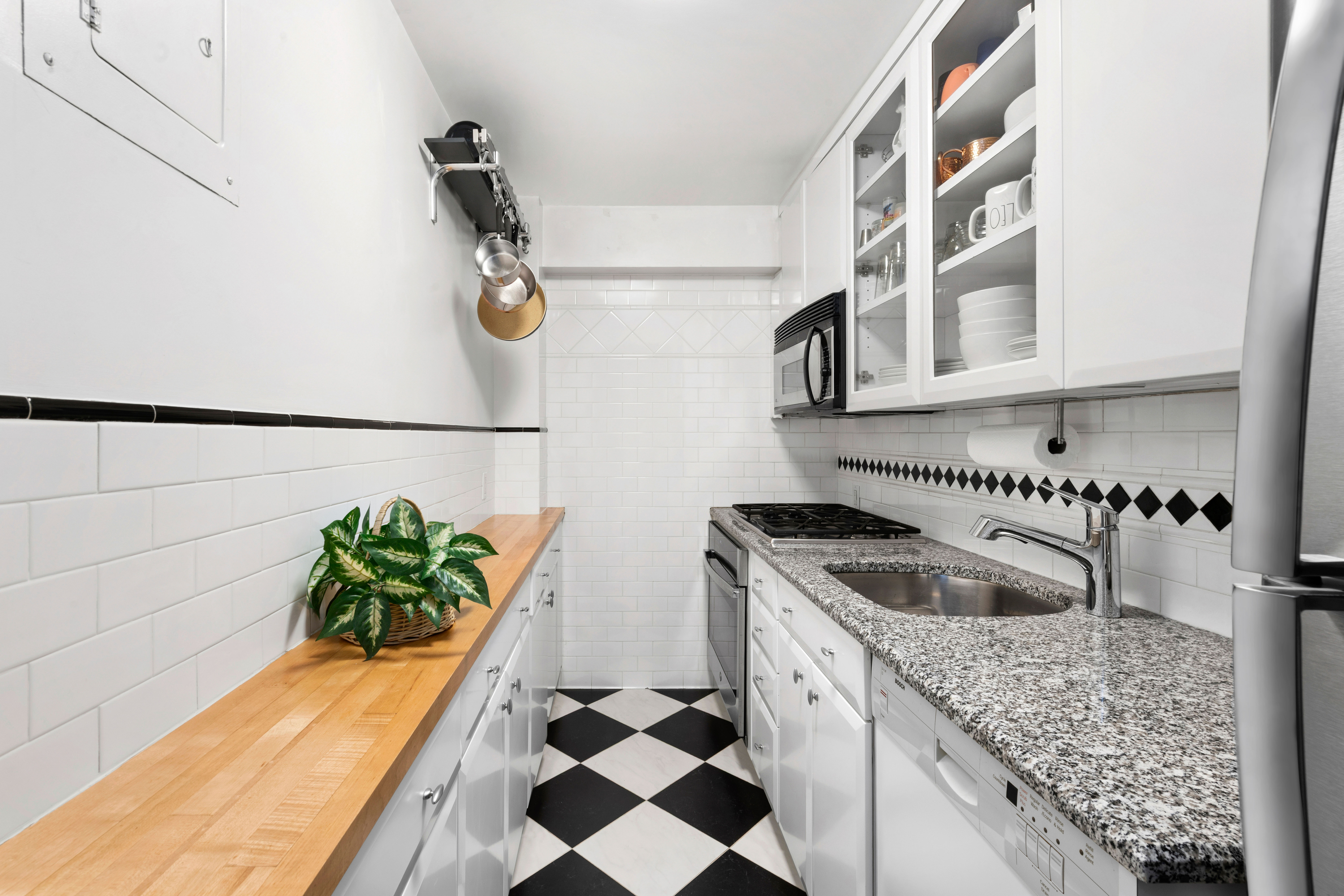 205 East 77th Street, Unit 4B Manhattan, NY 10075 - Photo 5 of 10 a kitchen with stainless steel appliances granite countertop a sink and a stove