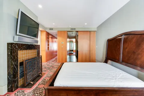 a large bedroom with a bed and wooden floor