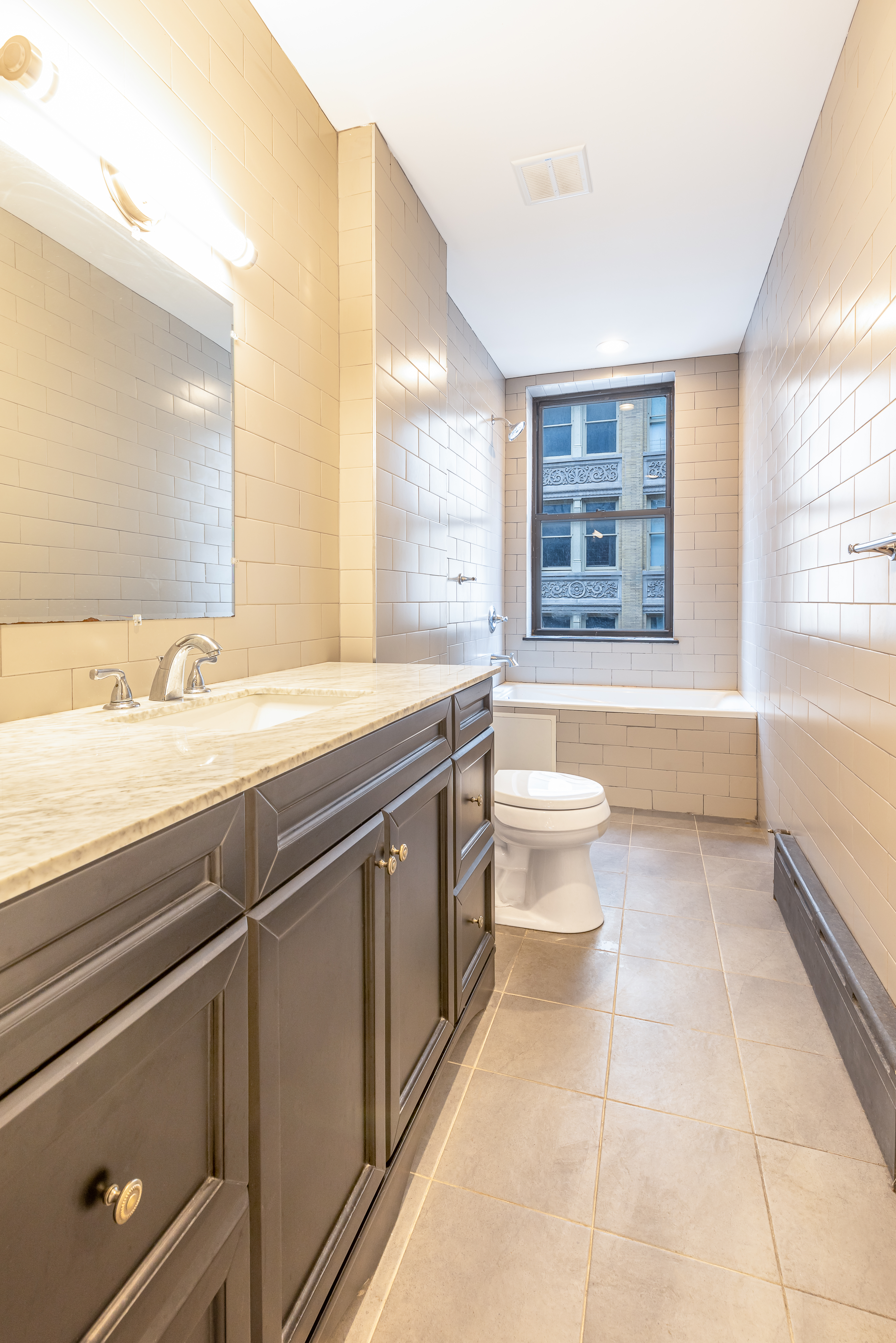 61 Lispenard Street, Unit 4 Manhattan, NY 10013 - Photo 7 of 8 a bathroom with a sink a toilet and bathtub
