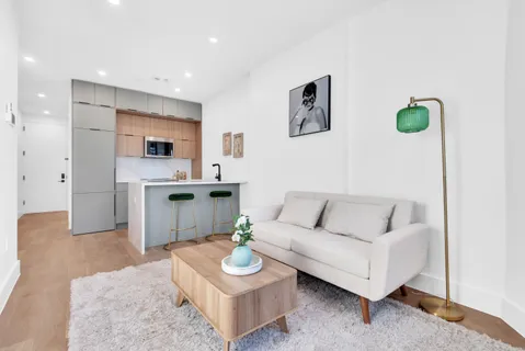 a living room with furniture and kitchen view
