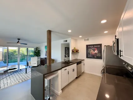 a kitchen with stainless steel appliances granite countertop a sink and a refrigerator
