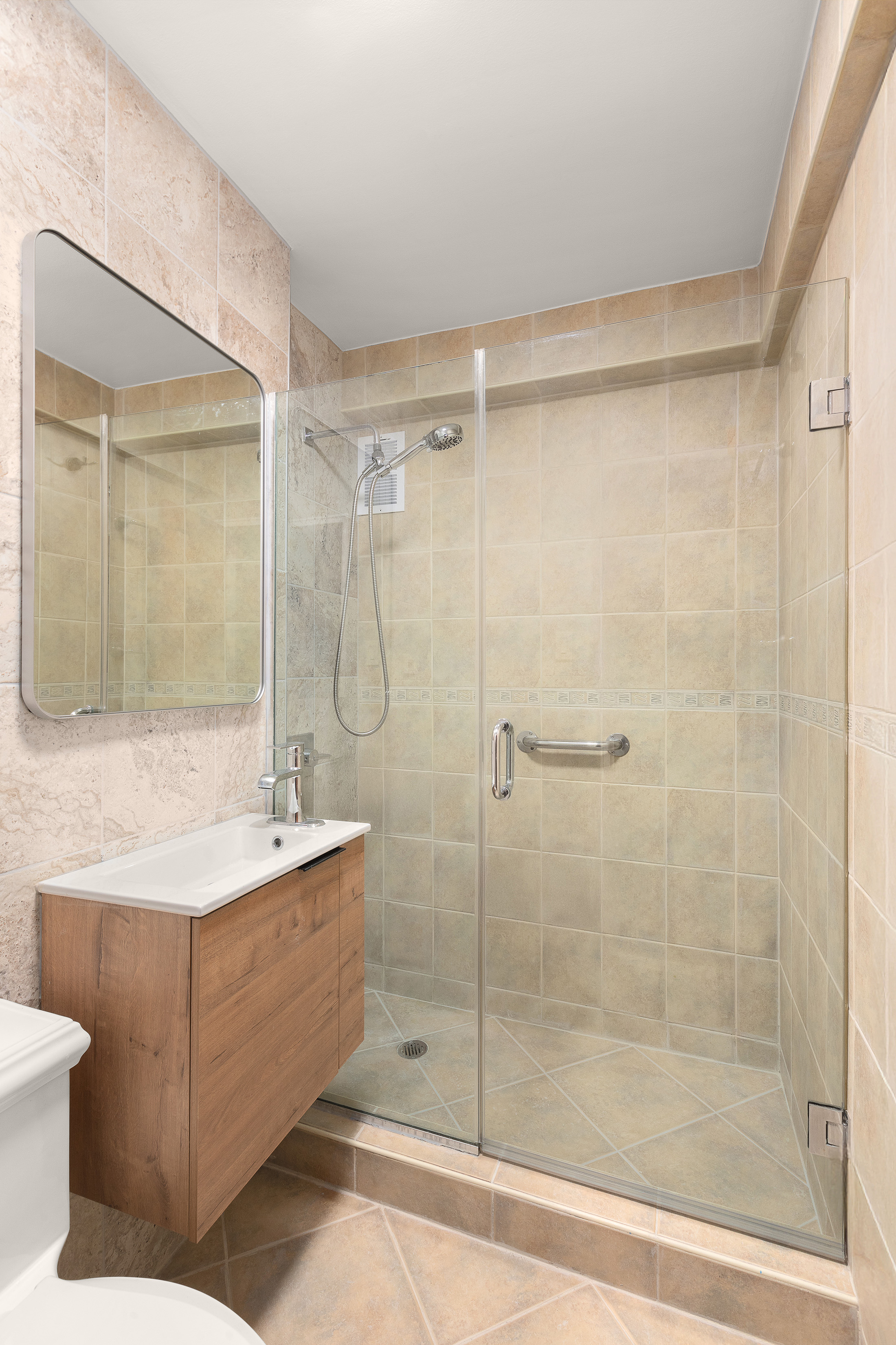 425 East 63rd Street, Unit E7A Manhattan, NY 10065 - Photo 5 of 13 a bathroom with a shower a sink and a mirror