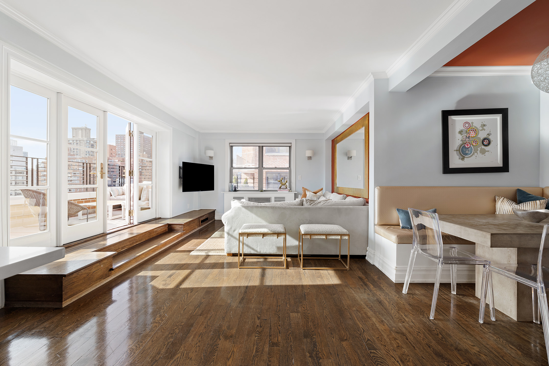 136 East 76th Street, Unit 16DE Manhattan, NY 10021 - Photo 6 of 14 a living room with furniture large windows and wooden floor