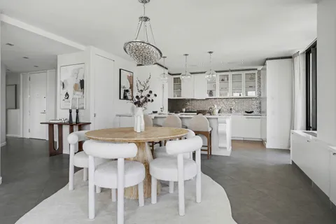 a dining room with stainless steel appliances kitchen island granite countertop a table and chairs