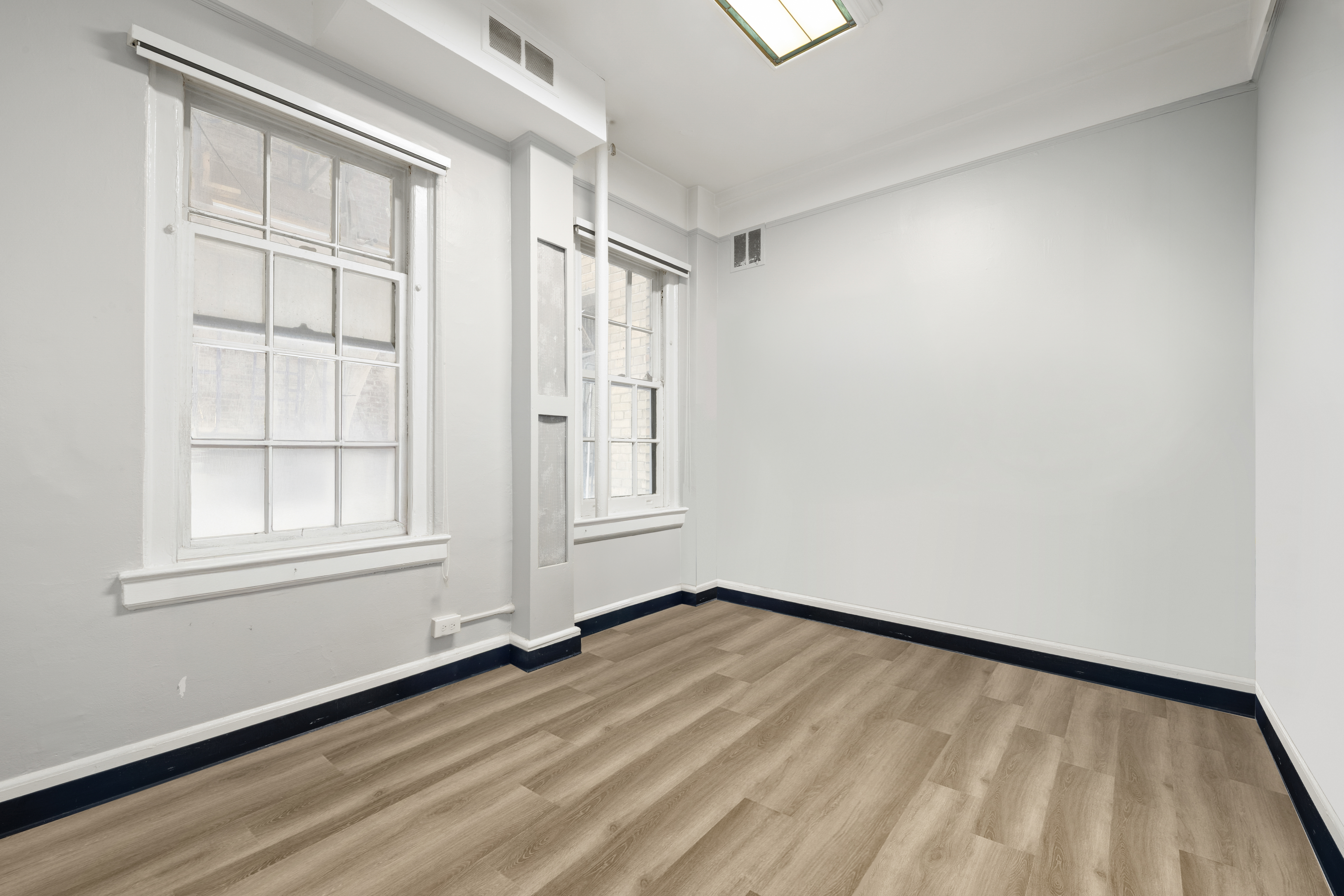 162 East 80th Street, Unit 1B Manhattan, NY 10075 - Photo 6 of 10 an empty room with wooden floor and windows